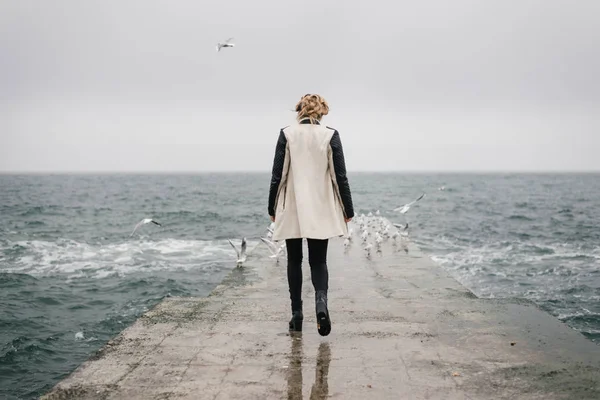 La femme revient sur la jetée et regarde la mer . — Photo