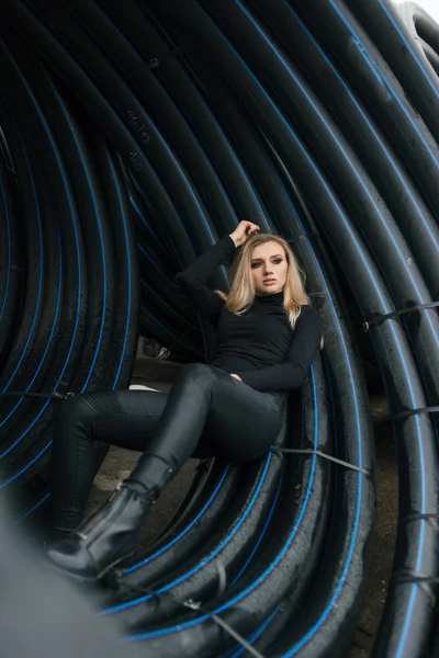 A girl in a canopy of pipes looking out into the distance — Stock Photo, Image