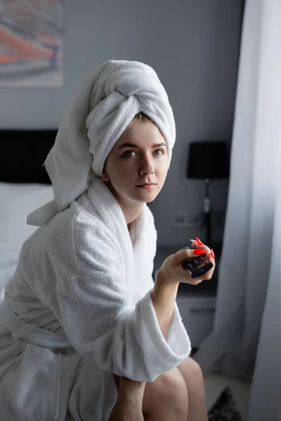 Hermosa joven sentada en la habitación, hombre después de la ducha viendo la televisión . — Foto de Stock