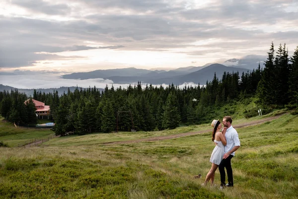 Een man en een vrouw knuffelen en kijken elkaar aan tegen de achtergrond van het bos — Stockfoto