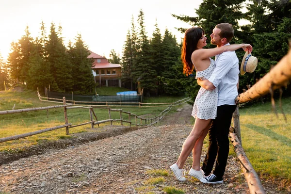 Muž a dívka se objímají a dívají se na sebe, jehličnatý les, boční pohled — Stock fotografie