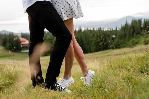 Las piernas de un hombre y una mujer en el fondo de la naturaleza de montaña —  Fotos de Stock