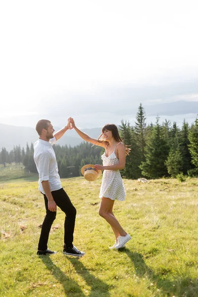 Девушка и парень подняли руки вверх, на фоне горной природы — стоковое фото