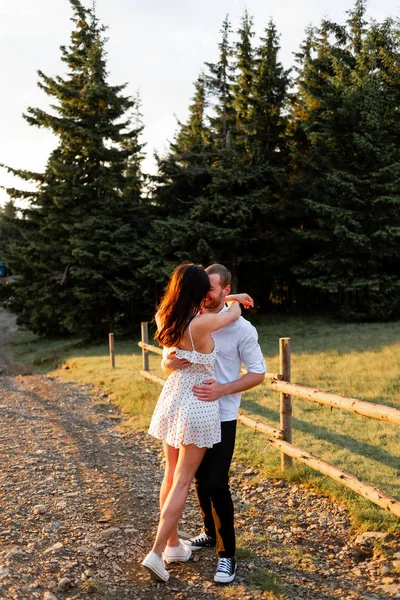 Пара закоханих обіймає і сміється на фоні лісу — стокове фото