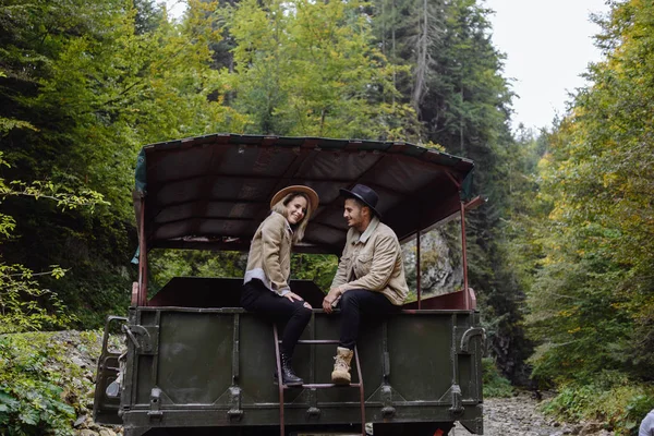 Un hombre y una mujer viajan en un camión en un camino forestal — Foto de Stock