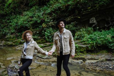 Bir çift turist el ele tutuşarak yukarı bakıyor.