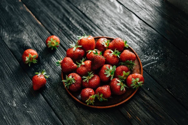 Harvest ripe strawberries on a table made of ebony — Stockfoto