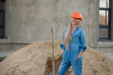 Kız gülümser ve elinde bir kürek tutar.