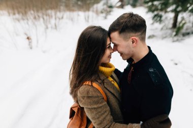 Bir adam ve bir kız karda sarılıyorlar.