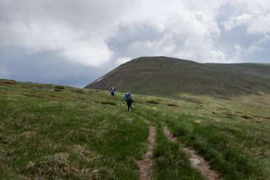 Turistler dağlarda uzun yollar kat ederler.
