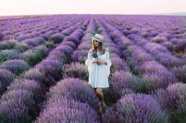 Beautiful brunette holds a bouquet in a lavender field