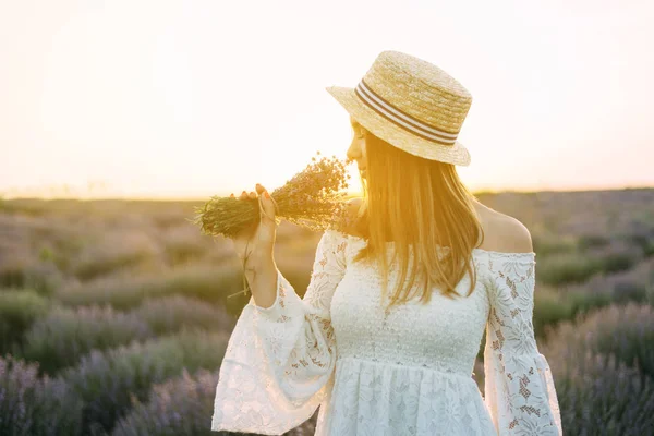 A woman sniffs her bouquet of lavender, lavender field in the su — 图库照片