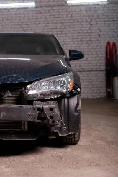 Foto de um carro preto após um acidente, o carro está sendo reparado no centro de serviço — Fotografia de Stock