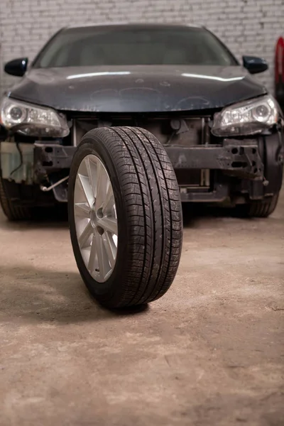 Foto de um pneu de carro no fundo de um carro na garagem — Fotografia de Stock