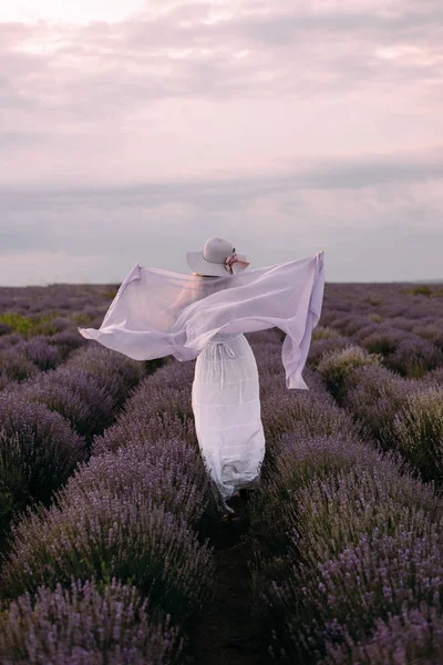 Une fille court sur un champ de lavande en robe blanche et un foulard, France, Provence — Photo