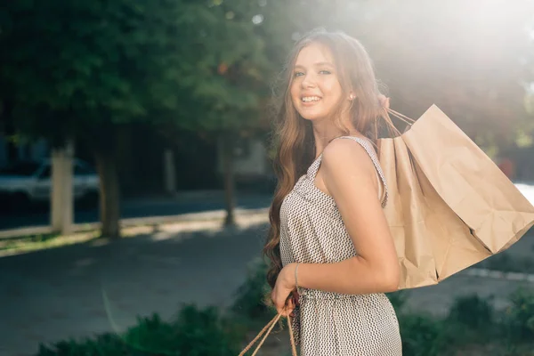 Shoppingtjejen. Vintage stil foto leende flicka har en framgångsrik shopping, promenader på gatan — Stockfoto