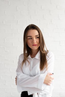 Beyaz gömlekli genç bir kız kollarını kendine dayadı ve utangaçlığını, beyaz geçmişini ifade etti.