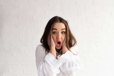 Genç esmer kadın ellerini kafasından tuttu ve şaşkınlıkla ağzını açtı.