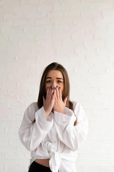 Omg, the girl is very surprised and covers her mouth with her hand, a surprised woman on a white background — Stock Photo, Image