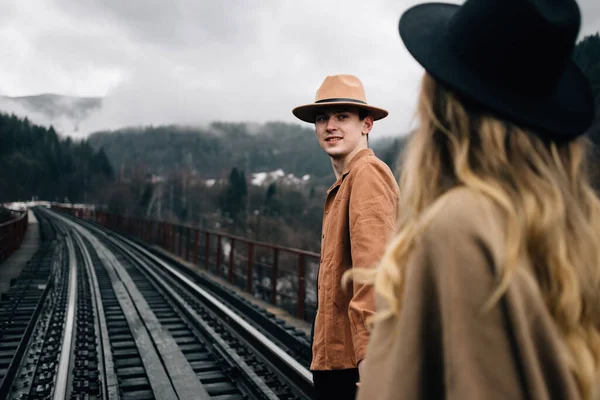 young beautiful couple of adventurers, stylish male and female hat, walking on the jelly road, treasure seekers.