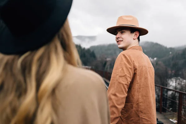 Europe tours concept. Jeune couple élégant marche dans la nature. Le gars tient la fille par la main et la regarde attentivement . — Photo