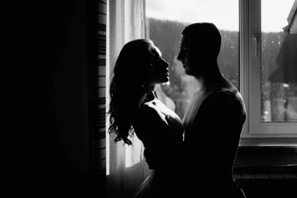 Silhueta da noiva e do noivo junto à janela. Maravilhosa manhã de casamento. grande dia . — Fotografia de Stock