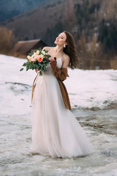 Lovely young stylish bride on a background of a winter forest.