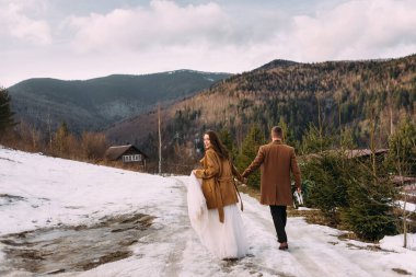 wedding walk among the alpine mountains. Young stylish couple bride and groom.