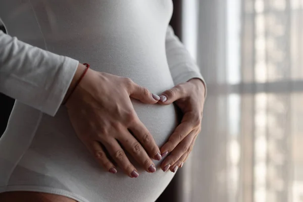 Mujer feliz embarazada tocándose el vientre. El concepto de un embarazo saludable y un bebé maravilloso. C — Foto de Stock