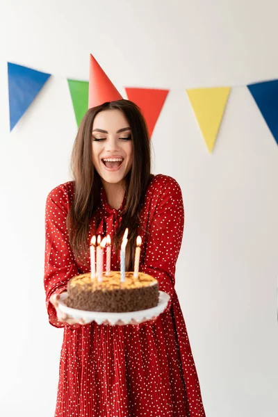 祝您生日快乐 身材好的漂亮时髦的女孩手里拿着一个蛋糕 笑得漂亮蛋糕上的蜡烛 文案文的派对场所 — 图库照片