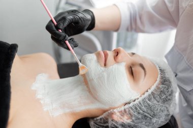 Masaj masasında yatan kıza canlandırıcı bir maske verilir. Stratum korneumundaki ölü hücrelerin derisini temizler..
