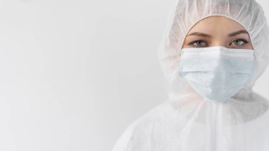 Coronavirus 'a karşı koruma, koruyucu elbise giymiş bir kadının yakın plan portresi. Yüzünde maske var. Metin için yer