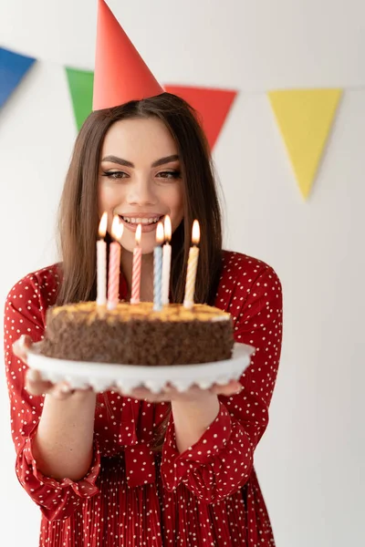 生日假期 一个年轻的女人手里拿着一个美味的蛋糕 在上面点着蜡烛 许个愿 吹灭蜡烛 — 图库照片