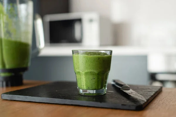 tasty and healthy food for vegetarians. Green smoothie of vegetables and fresh herbs is poured into a glass. Natural antioxidant. healthy eating concept