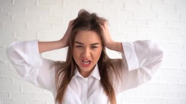 Neşeli güzel bir kadın baş parmağını bükülmüş bir yumruğa kaldırır. Yüzünde bir gülümseme, eğlence ve neşe. Her şey yoluna girecek.