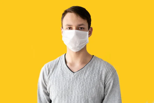 Närbild Porträtt Ung Man Skyddande Medicinsk Mask Ansiktet Gul Bakgrund — Stockfoto