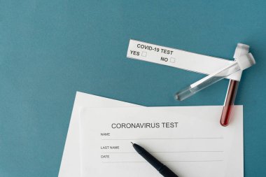 Bir vakum test tüpündeki mavi arkaplan kan örneklerinde. Coronavirus analizi sonuçları