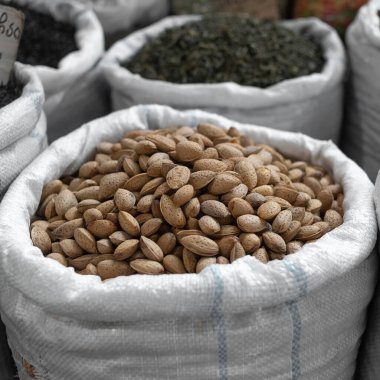 Georgia 'daki Tiflis pazarında bir torba badem. Kabukta soyulmamış ceviz. Sağlıklı bir diyet için faydalı ve ağız sulandırıcı atıştırmalıklar..