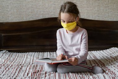 Küçük kız liseli kız okula uzaktan bağlanmış. Salgın ve karantina sırasında uzak eğitim kavramı. Tıbbi maske takıldı.