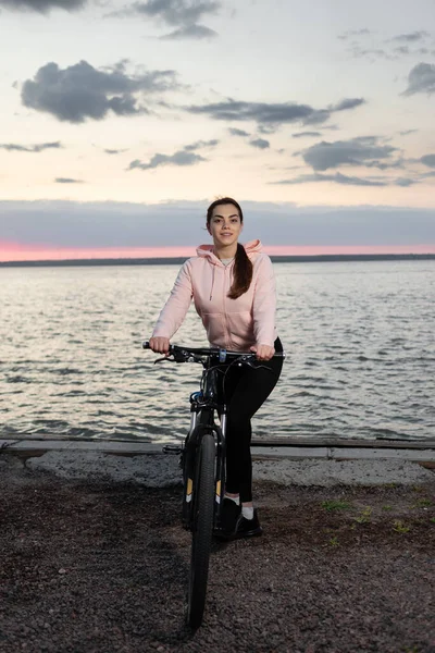 Dziewczyna Sportowiec Rowerze Jest Zaangażowany Jazdę Rowerze Plaży Tle Nieba — Zdjęcie stockowe