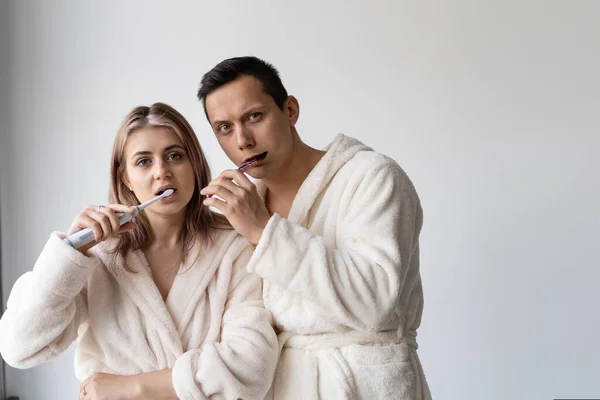 Casal apaixonado de manhã cedo escovar os dentes juntos. Uma família feliz . — Fotografia de Stock