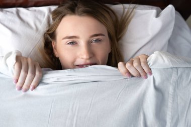 Uyuduktan sonra harika bir ruh hali. Güzel bir rüya. Uyuduktan sonra bir kadının portresi. Ağzı battaniyeyle örtülmüş kameraya bakıyordu.