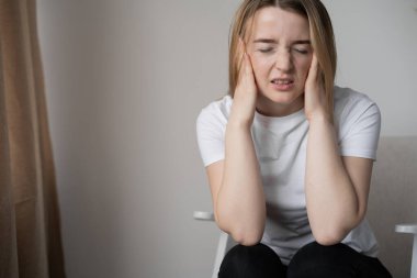 Genç ve güzel bir kadının evinde koltukta oturup ağırlığına masaj yapması bunalımlı bir durum. İş yerindeki stres sonucu baş ağrısı ve migren ağrıları