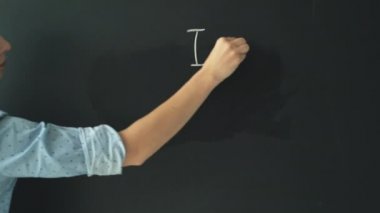 Güzel bir el yazısıyla bir kadın siyah tebeşirle 