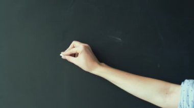 Kadın eli, A, B, C. Tahtasına beyaz tebeşirle İngilizce harfler yazıyor. Öğretmen çocuklara öğretiyor.