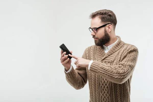 Ung man trycker på skärmen på sin telefon — Stockfoto