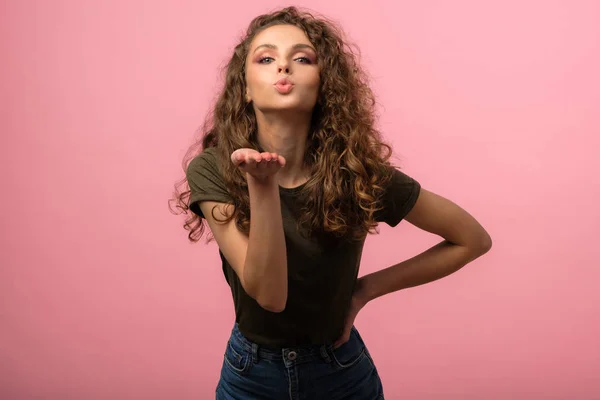 Hübsches Mädchen bläst einen Kuss isoliert auf rosa Hintergrund — Stockfoto