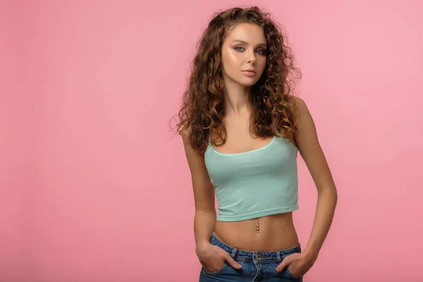 Pretty female with curly hair on pink background — Stock Photo, Image