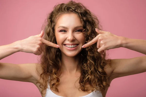 Menina feliz com cabelo encaracolado e aparelho dentário — Fotografia de Stock