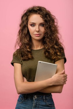 Pembe arka planda tableti olan güzel kız.